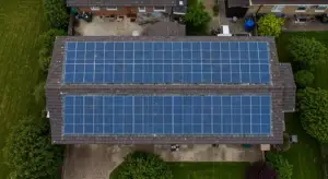 Inline Image Prompt 2 (Size & Usable Space): "Aerial drone photograph looking down onto a large, simple rectangular tiled roof of a UK home. The roof surface is almost entirely covered with a grid of perfectly aligned solar panels, demonstrating efficient use of available space. Clear, bright daylight conditions, highlighting the scale of the installation."